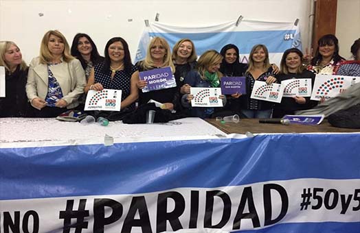 Grupo de mujeres luchando por la paridad en la toma de decisiones entre mujeres y varones