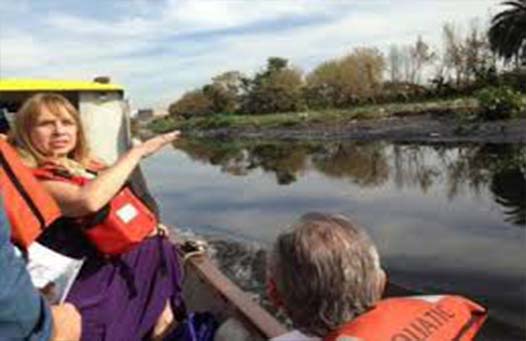 María José Lubertino junto a otras personas navegando el riachuelo analizando su sanación